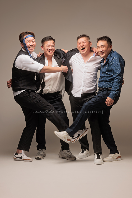 巧靈公司的團隊，每一年都會依尾牙的主題來拍團隊形象照，去年的主題很幽默，拍起來每一張都像電影劇照，大家在鏡頭前完全演技魂上身，這張是四位男同事肩併肩站靠在一起、最外面的兩位各一腳踢在一起、四位都笑得很歡樂、是一張很有趣很幽默且很像劇照的一張團體形象照！