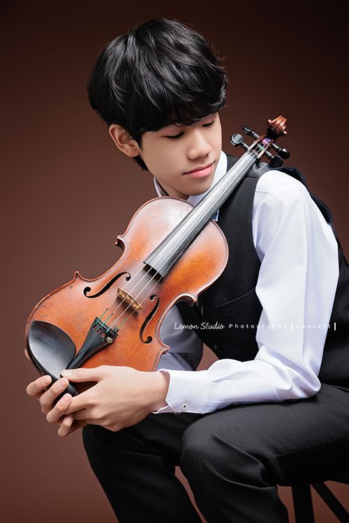 Timmy即將國中畢業，帶著他熟悉的提琴，站進鏡頭裡，黎爸捕捉了他不同的角度與情緒，這張是Timmy兩手拿著提琴在身旁、側身轉頭看向提琴的一張很有意境的音樂寫真照！