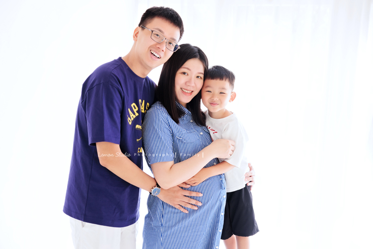 彥鈞爸拔一家來拍家庭寫真，媽麻肚子裡有可愛的二寶，哥哥開朗又活潑，和爸拔媽麻的互動充滿笑聲，這張是一家三口抱在一起拍的全家福，全家人都看著鏡頭微笑著！