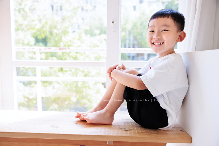 彥鈞爸拔一家來拍家庭寫真，媽麻肚子裡有可愛的二寶，哥哥開朗又活潑，和爸拔媽麻的互動充滿笑聲，這張是哥哥坐在窗前，看著遠方微笑著的可愛個人兒童寫真照！
