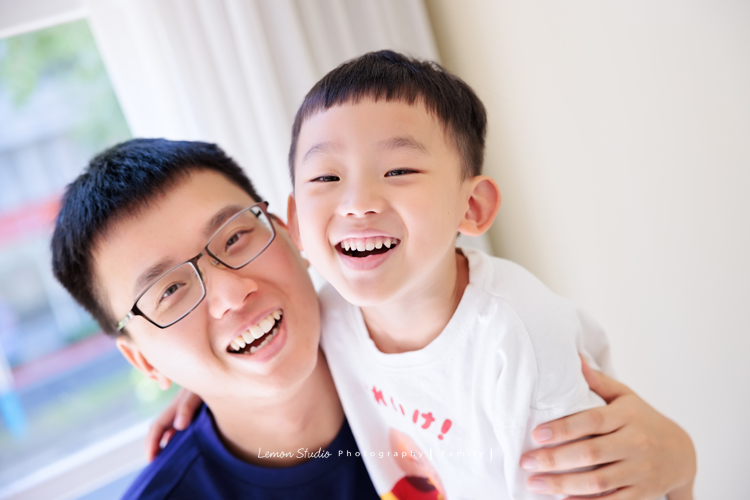 彥鈞爸拔一家來拍家庭寫真，媽麻肚子裡有可愛的二寶，哥哥開朗又活潑，和爸拔媽麻的互動充滿笑聲，這張是爸拔抱著哥哥、兩人看著鏡頭笑得很開心的互動紀錄！
