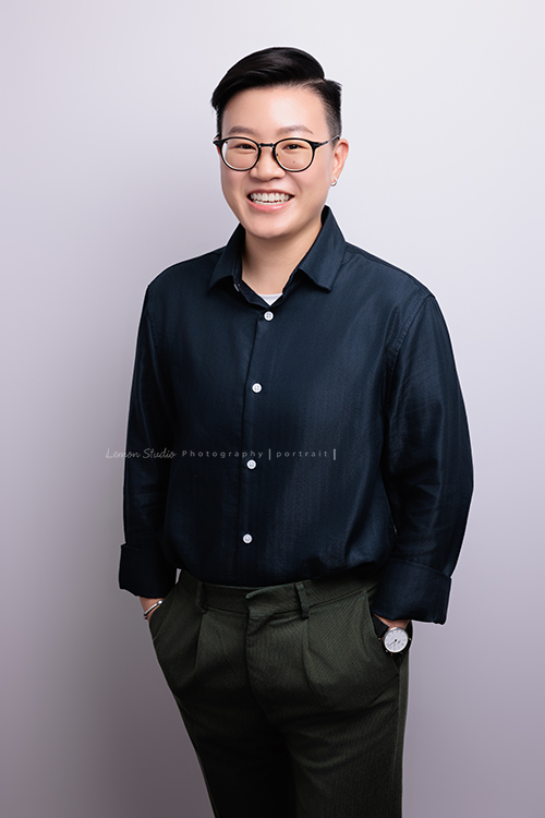 很榮幸再次為充滿幸福感的企業拍攝內部人員的形象照，這次拍了許多不同的部門的成員，企業形象照在無形之中，也為公司整體的形象與質感，多添了一份專業與信任感，這張是企業內部的一位女職員穿上深藍色的襯衫、雙手放在口袋裡，微笑地看著鏡頭的一張很有質感的形象照！