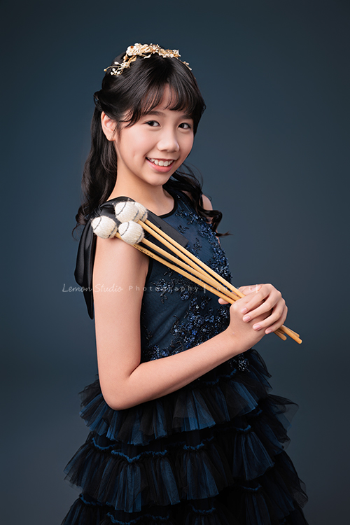 音樂班的 Lily畢業前來拍音樂班畢業音樂寫真照，Lily的活潑與大方在鏡頭前自然流露，這張是Lily穿著一襲深藍色的禮服、拿著馬林巴木琴槌在身旁，側身轉頭過來看著鏡頭笑得很甜美的一張音樂班畢業音樂寫真照！