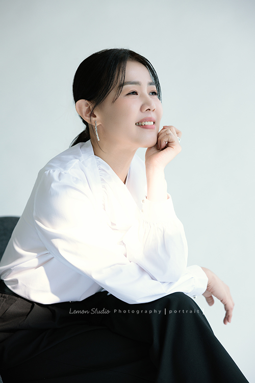 形象顧問Ivy的形象照，很喜歡她在鏡頭前的肢體語言，對整體形象＆服裝的搭配有很多想法的她，目前也和我們合作，這張是Ivy穿上白色很有特色的上衣、側坐在椅上、一手托著下巴微笑地看著遠方、是一張很美很有意境的形象顧問形象照！