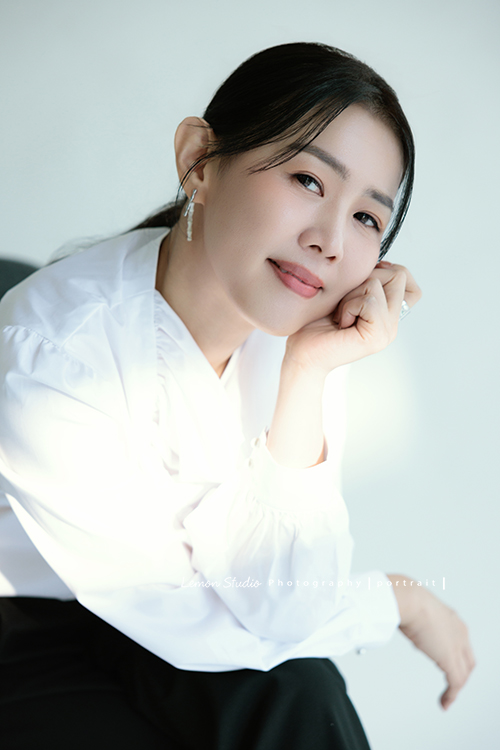 形象顧問Ivy的形象照，很喜歡她在鏡頭前的肢體語言，對整體形象＆服裝的搭配有很多想法的她，目前也和我們合作，這張是Ivy穿上白色很有特色的上衣、側坐在椅上、一手托著下巴轉過頭來沈穩地看著鏡頭、是一張很美很有意境的形象顧問形象照！