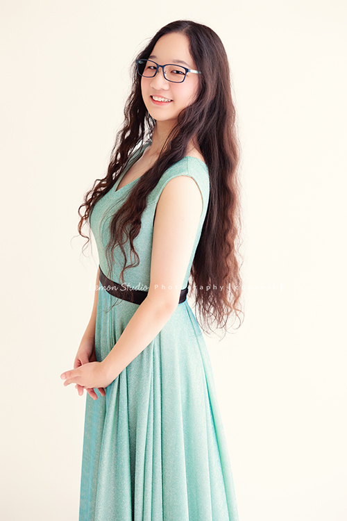 就讀高中音樂班主修鋼琴的Diana，來拍屬於她的音樂寫真，黎爸拍下兩種截然不同感覺的Diana，這張是Diana穿著一襲水綠色的小禮服，戴上眼鏡，側站著雙手在身體前方，轉過頭來看著鏡頭甜美地微笑著，是一張很美的音樂寫真照！