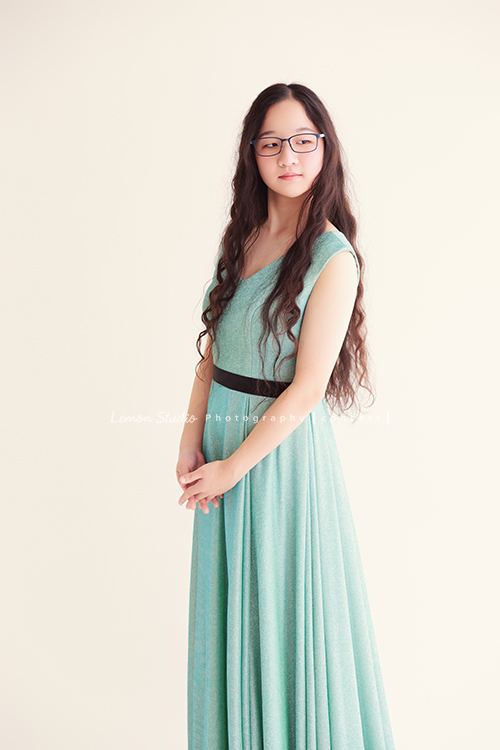 就讀高中音樂班主修鋼琴的Diana，來拍屬於她的音樂寫真，黎爸拍下兩種截然不同感覺的Diana，這張是Diana穿著一襲水綠色的小禮服，側站著雙手在身體前方，轉過頭來看向側後方，是一張很美的音樂寫真照！