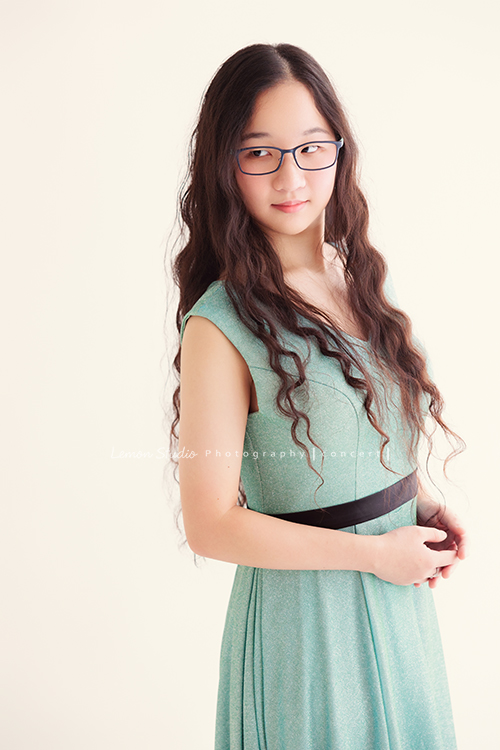 就讀高中音樂班主修鋼琴的Diana，來拍屬於她的音樂寫真，黎爸拍下兩種截然不同感覺的Diana，這張是Diana穿著一襲水綠色的小禮服、戴上眼鏡，站著雙手在身體前方，微微地看向側邊，是一張有知性美的音樂寫真照！