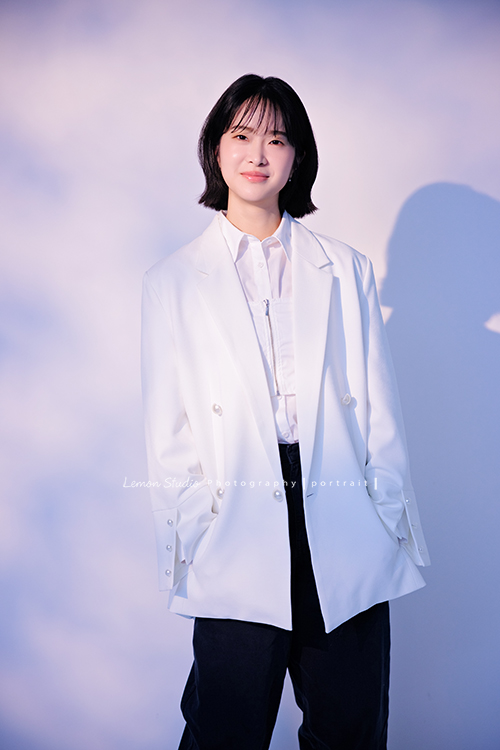 講師Tiffany來拍照，這次我們一起整理出帶點日韓系的風格，有些細微的表情與狀態，很耐看，這張是Tiffany身穿白色外套，雙手放在口袋裡、看著鏡頭微笑的形象照！