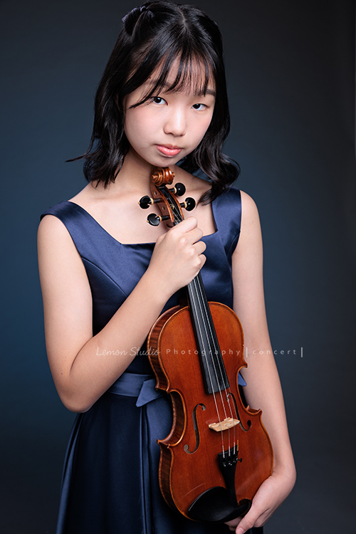 岑即將從國小弦樂團畢業,這一天,我們拍下了許多不同樣子的岑,把這些輕輕停留的瞬間,就讓相片替她好好留住,這張是岑身穿藍色小禮服、雙手拿著提琴、酷酷地看鏡頭的一張音樂寫真照!