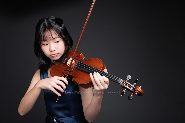 岑即將從國小弦樂團畢業,這一天,我們拍下了許多不同樣子的岑,把這些輕輕停留的瞬間,就讓相片替她好好留住,這張是岑身穿藍色小禮服、手拿著提琴及弓、正在拉提琴沒有看鏡頭的一張音樂寫真照!
