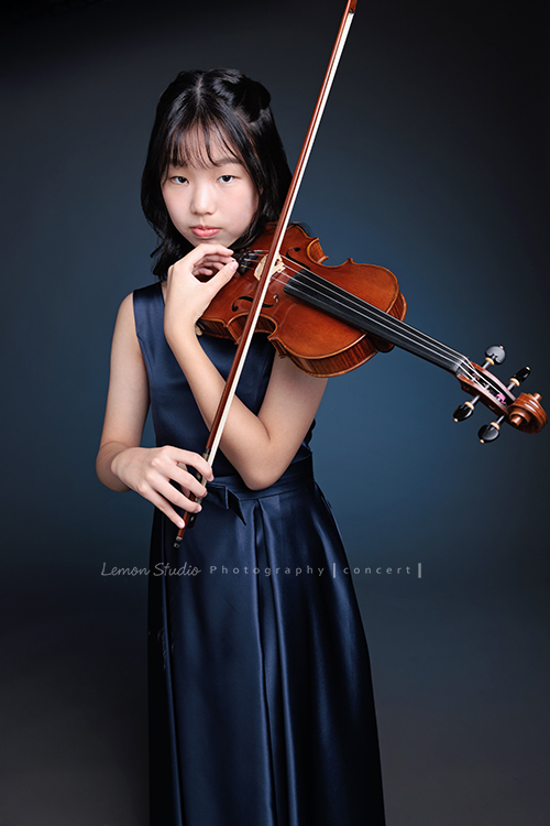 岑即將從國小弦樂團畢業,這一天,我們拍下了許多不同樣子的岑,把這些輕輕停留的瞬間,就讓相片替她好好留住,這張是岑身穿藍色小禮服、手拿著提琴及弓、酷酷地看鏡頭的一張音樂寫真照!