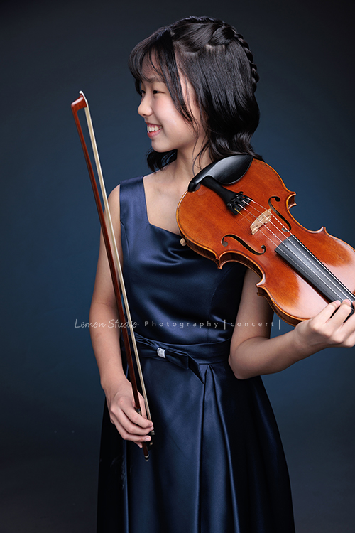 岑即將從國小弦樂團畢業,這一天,我們拍下了許多不同樣子的岑,把這些輕輕停留的瞬間,就讓相片替她好好留住,這張是岑身穿藍色小禮服、雙手拿著提琴及弓、微笑著沒有看鏡頭的一張音樂寫真照!