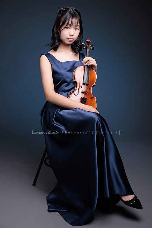 岑即將從國小弦樂團畢業,這一天,我們拍下了許多不同樣子的岑,把這些輕輕停留的瞬間,就讓相片替她好好留住,這張是岑身穿藍色小禮服、坐在椅子上雙手拿著提琴、酷酷地看鏡頭的一張音樂寫真照!