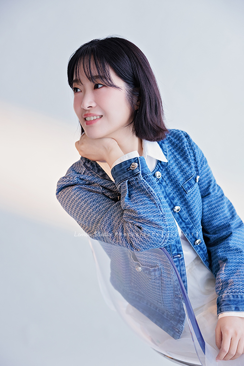 講師Tiffany來拍照，這次我們一起整理出帶點日韓系的風格，有些細微的表情與狀態，很耐看，這張是Tiffany身穿藍色短版外套及白色長裙坐在椅子上、身體靠著椅子、一手放在脖子處、沒有看鏡頭的一張很美的形象照！