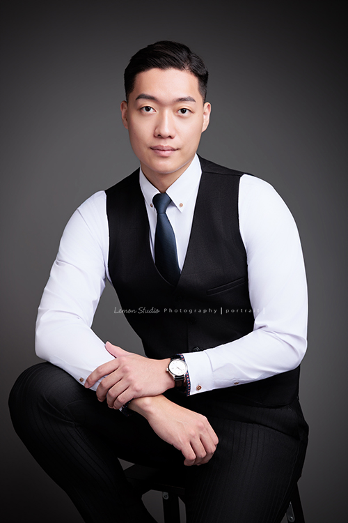 圓璽不動產專業服務顧問Michael來拍形象照,高大俊挺的Michael拍出專業感的形象照,這張是Michael穿著白色襯衫及背心、坐在椅上,兩手很自然地放在腿上,自信且沈穩地看著鏡頭的一張很帥氣的房仲形象照!