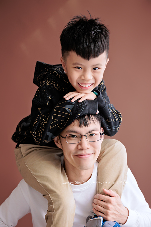小靜媽麻一家第四次來拍家庭寫真,一轉眼這次家裡多了一位超級可愛的新成員:五個月大的瑄妹,這次拍了好多可愛的畫面,這張是哥哥坐在爸拔肩膀上、雙手放在爸拔頭上、兩人看著鏡頭笑得很開心的父子寫真!