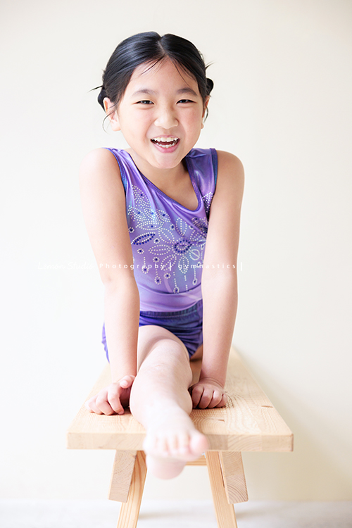 Vivien媽麻一家幾乎每年都會來拍照,三個孩子都在自己喜歡的領域裡成長著,這次小妹 Tiana帶著體操服來拍照,這張是Tiana身穿體操服在長木椅上做直劈腿的動作、並看著鏡頭笑容很燦爛,是一張很可愛的體操運動寫真!