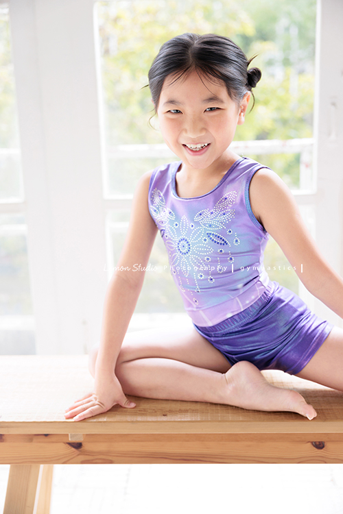 Vivien媽麻一家幾乎每年都會來拍照,三個孩子都在自己喜歡的領域裡成長著,這次小妹 Tiana帶著體操服來拍照,這張是Tiana坐在長木椅上、甜美地笑著看著鏡頭,是一張很可愛的體操運動寫真!
