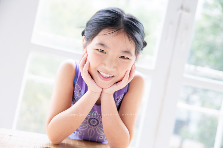 Vivien媽麻一家幾乎每年都會來拍照,三個孩子都在自己喜歡的領域裡成長著,這次小妹 Tiana帶著體操服來拍照,這張是Tiana穿著體操服兩手托著下巴兩側,看著鏡頭甜美地笑著,是一張很可愛的體操運動寫真!