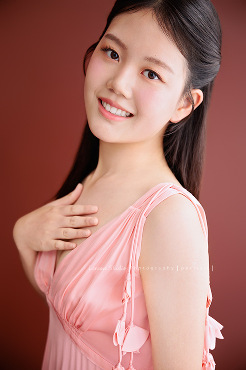 這次 Irene媽麻一家回台灣時,一樣預約了 Amber的形象照拍攝,再見到 Amber,又長大了好多,也多了幾分屬於大女孩的自信與從容,也恭喜 Amber在史丹佛大學展開新的生活,這張是Amber身穿一套粉色的小禮服,側身站著,一手放在胸前,對著鏡頭微笑的一張很美的形象照!