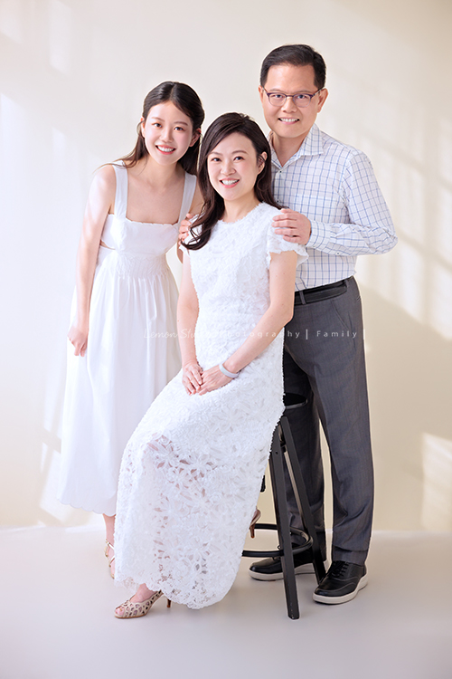 Irene媽麻一家暑假回台灣時來拍攝家庭照，今天先來分享一家三口的家庭照，Irene媽麻特別準備了白色系洋裝，一家三口在 Amber 即將踏入大學前，留下這段屬於一家人的珍貴時光，這張是Irene媽麻一家的全家福，Irene媽麻坐在中間，爸拔和Amber站在她的兩旁，一家人微笑著看著鏡頭！是一張很美很自然的全家福寫真！