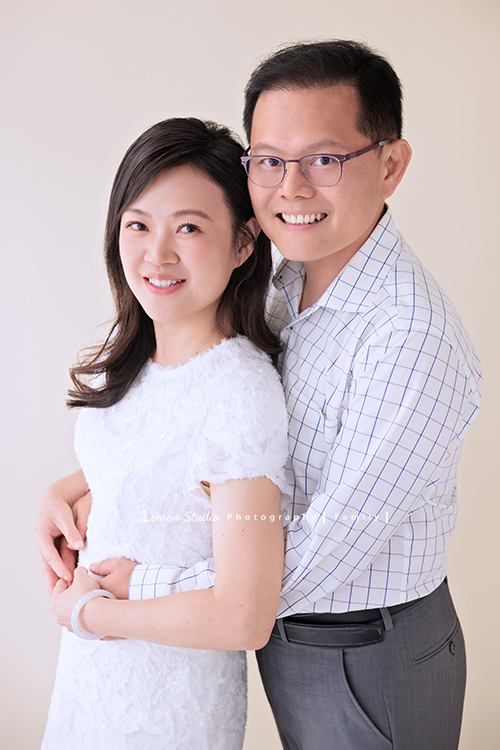 Irene媽麻一家暑假回台灣時來拍攝家庭照，今天先來分享一家三口的家庭照，Irene媽麻特別準備了白色系洋裝，一家三口在 Amber 即將踏入大學前，留下這段屬於一家人的珍貴時光，這張是Irene媽麻和先生的合照，先生從背後摟著Irene媽麻的腰，兩人微笑著看著鏡頭，是一張很美的夫妻寫真照！
