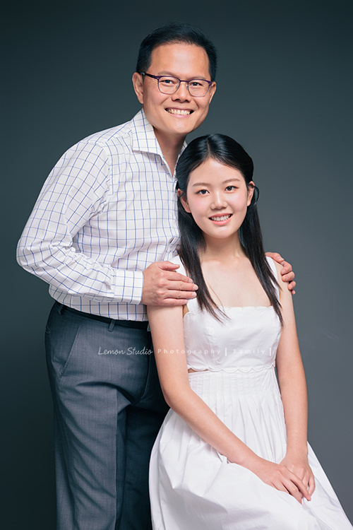Irene媽麻一家暑假回台灣時來拍攝家庭照，今天先來分享一家三口的家庭照，Irene媽麻特別準備了白色系洋裝，一家三口在 Amber 即將踏入大學前，留下這段屬於一家人的珍貴時光，這張是爸拔和女兒Amber的合照，Amber坐著、爸拔從背後搭著她的肩膀，兩人微笑著看著鏡頭，是一張很美的父女寫真！
